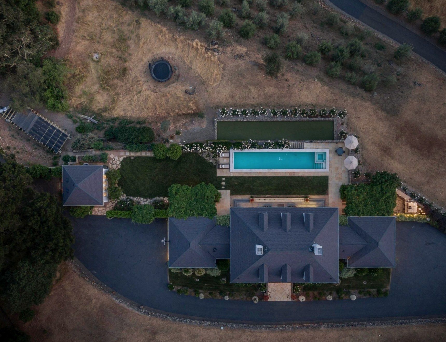 Aerial view of the property: house, pool, gardens, driveway